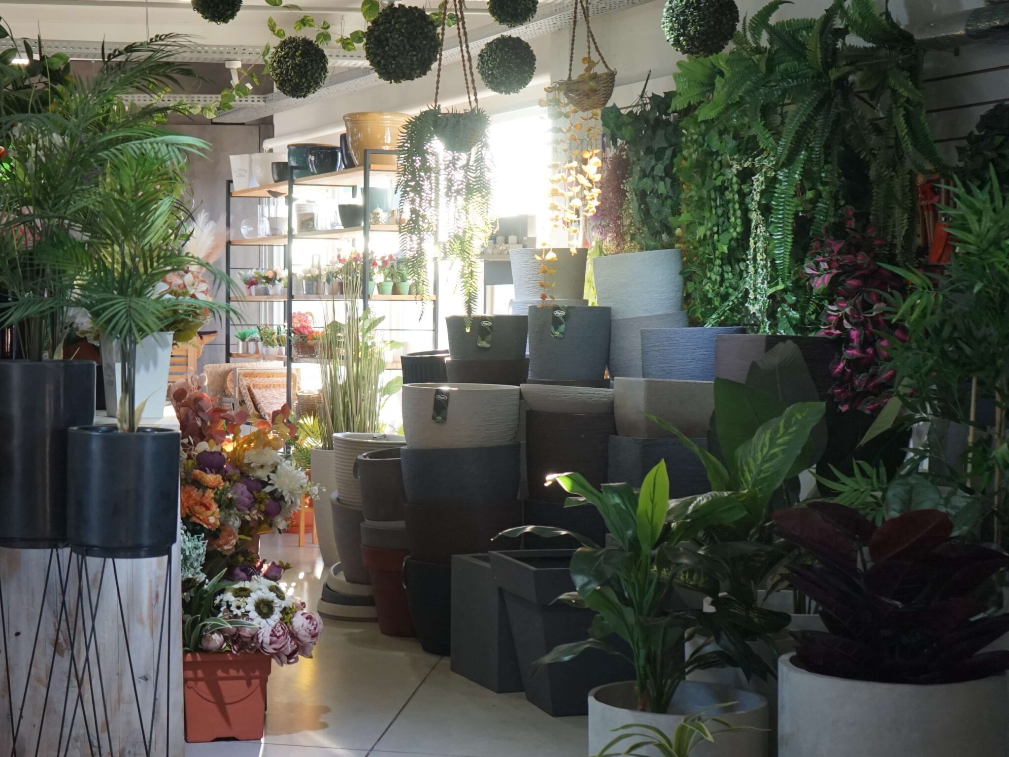 Variedad de macetas rodeadas de plantas artificiales